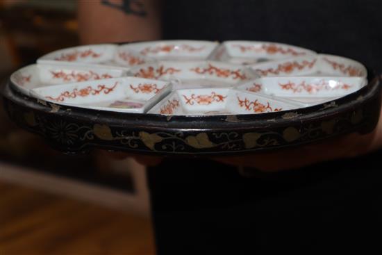 A 19th century Chinese famille rose immortals supper dish set, lacquer base only.